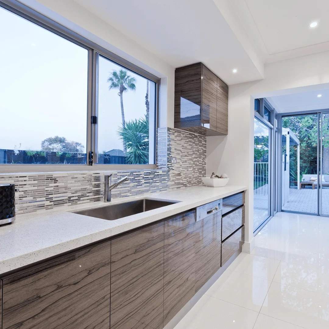 Kitchen with brown cabinet, white surface and palm tree view out of window