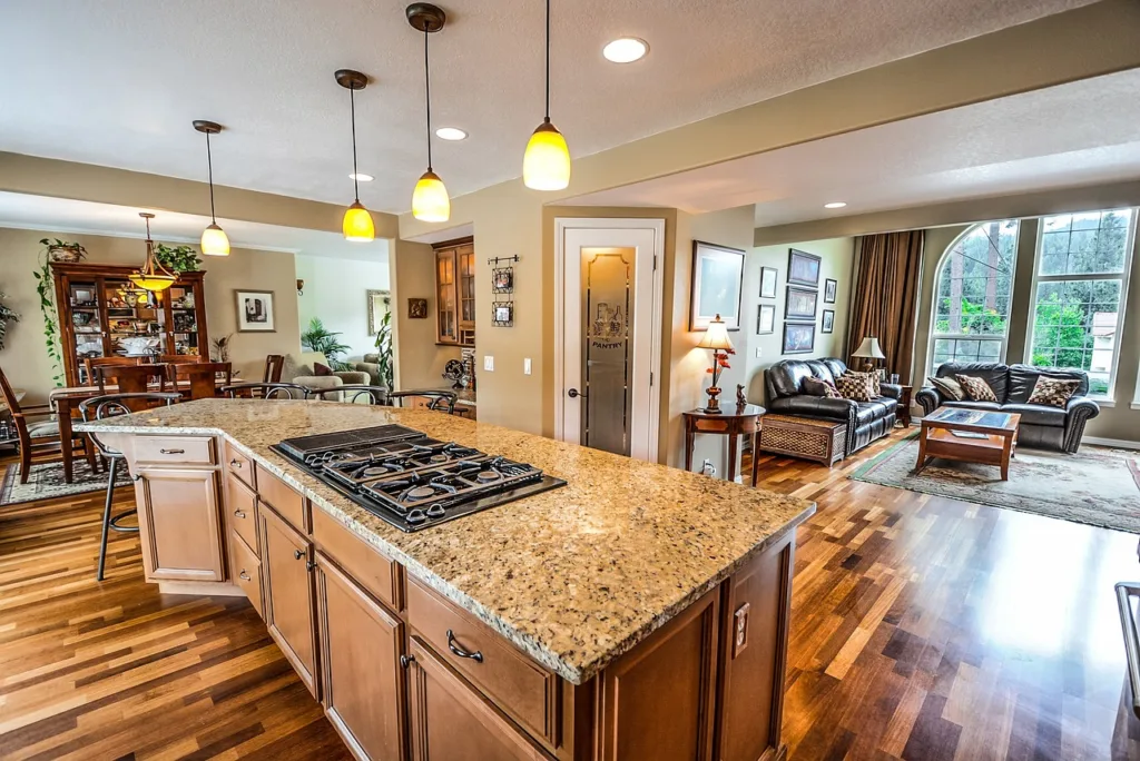 A picture of a kicthen with lighting & cabinets in a brown theme